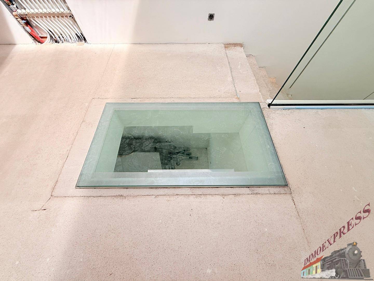Glasbodenplatte im Flur, die Licht in die darunterliegende Etage leitet.