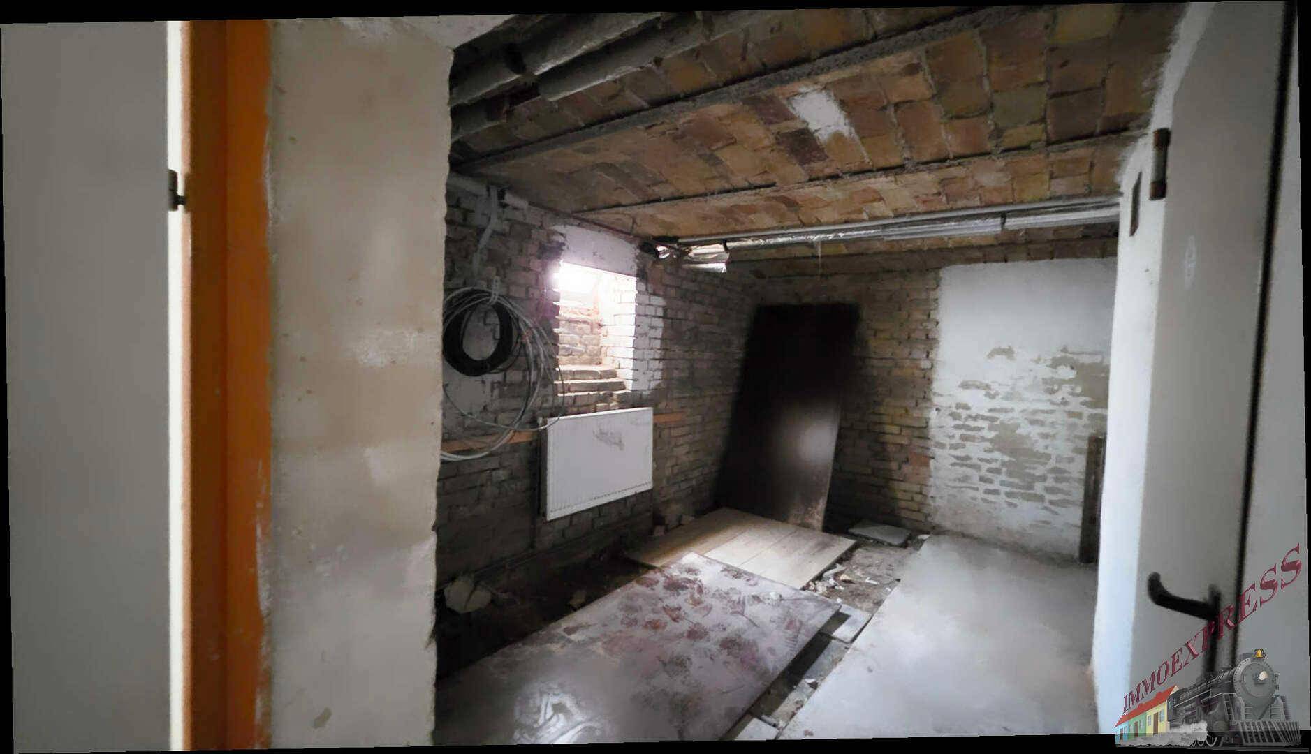 Unfertiger Kellerraum mit sichtbaren Ziegelwänden und Rohren, bereit für Ausbau.
