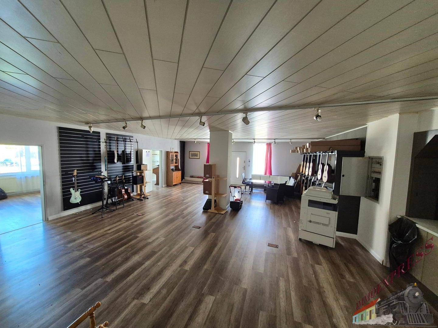 Geräumiger offener Raum mit Laminatboden und Musikinstrumenten, vielseitig nutzbar.