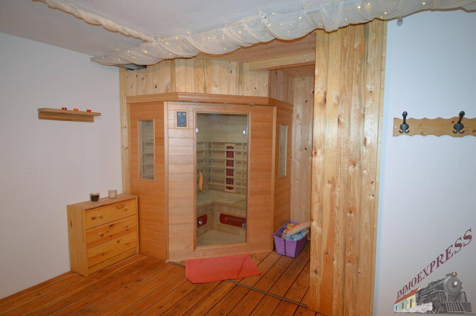 Wellnessbereich mit einer holzvertäfelten Sauna und Holzboden.