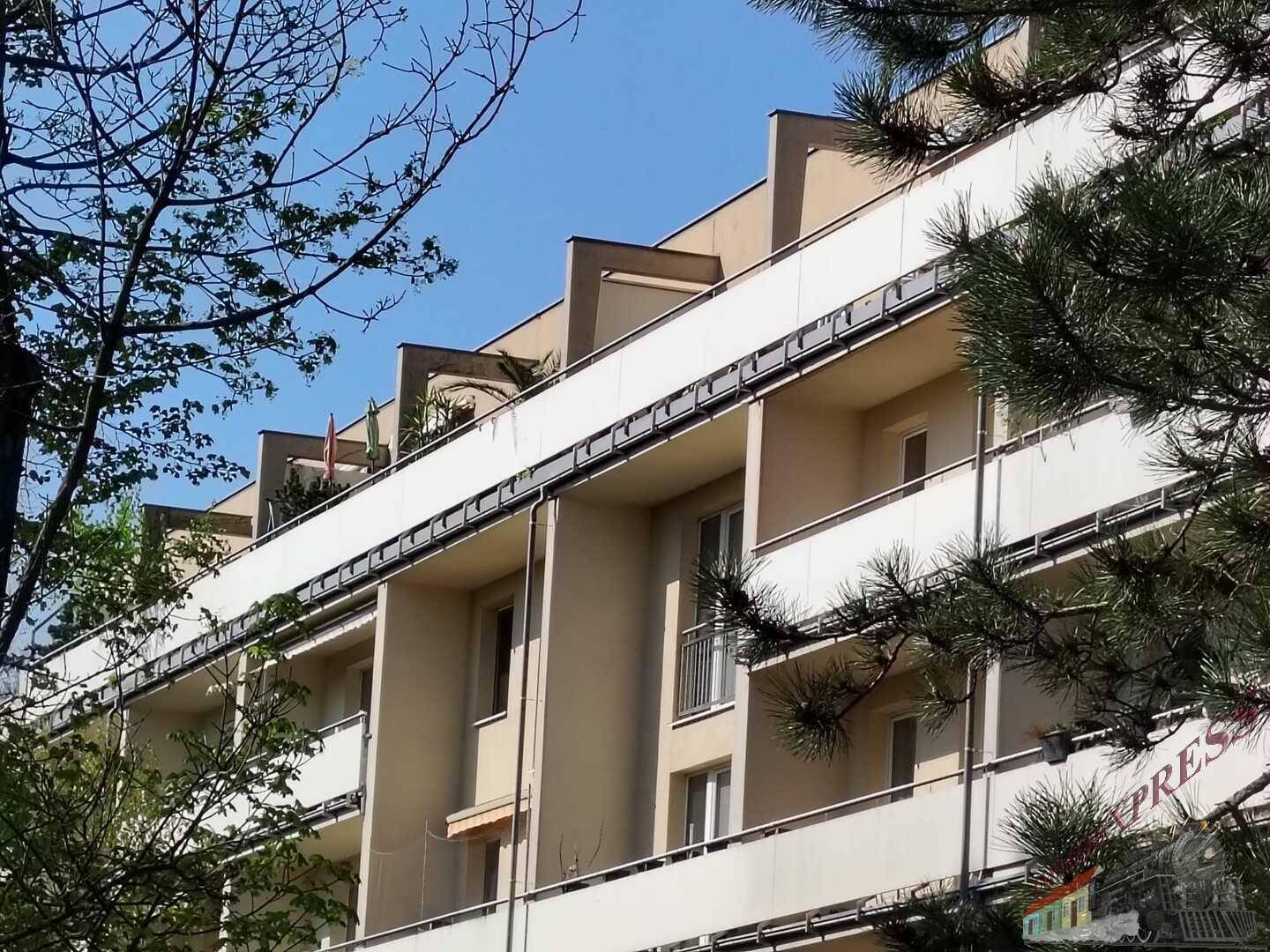 Moderne Gebäudefassade mit mehreren Balkonen und großen Fenstern unter blauem Himmel.