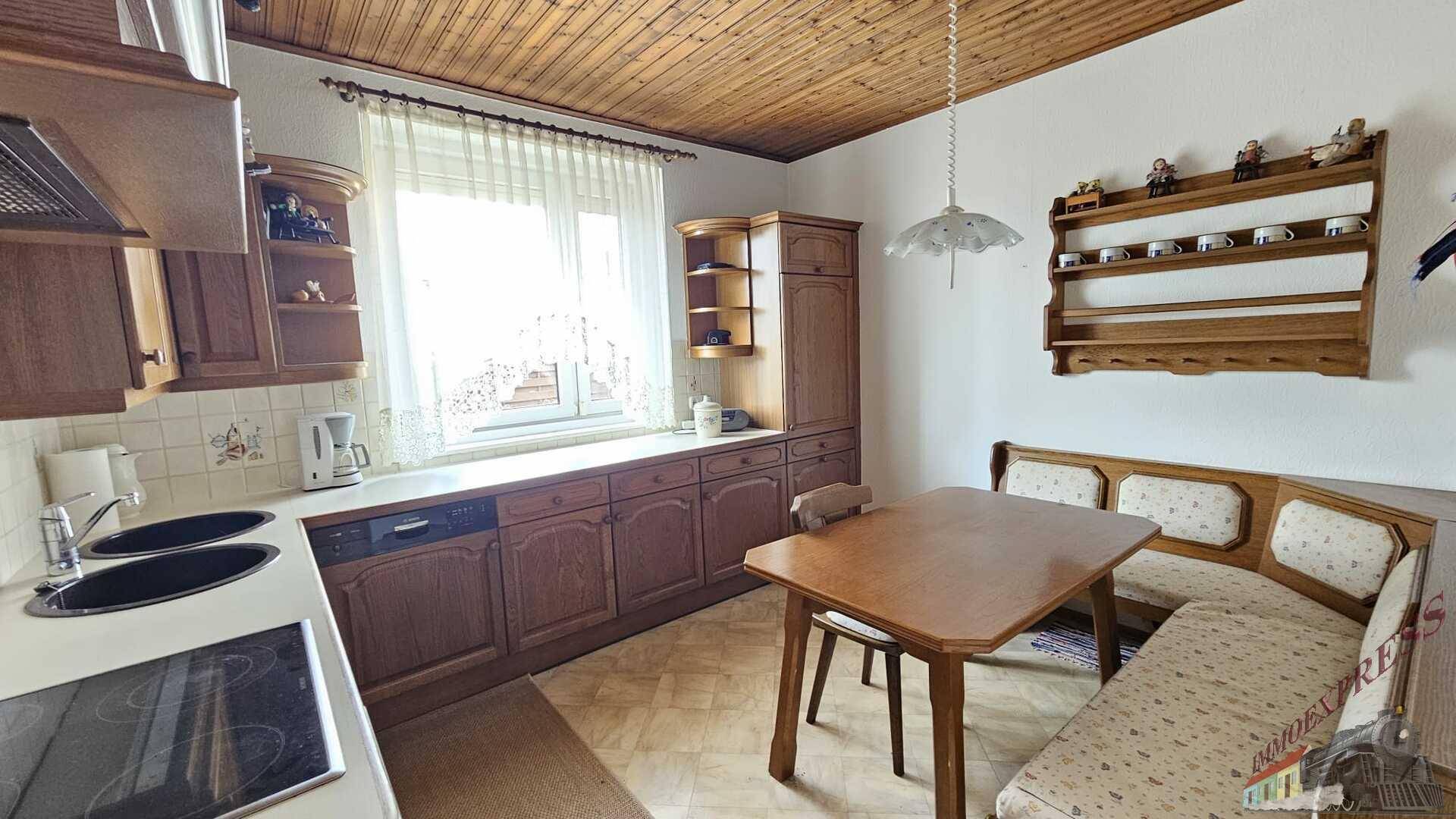 Traditionelle Küche mit Holzeinbauten, Essbereich und Fenster, ausgestattet mit Geschirrspüler.