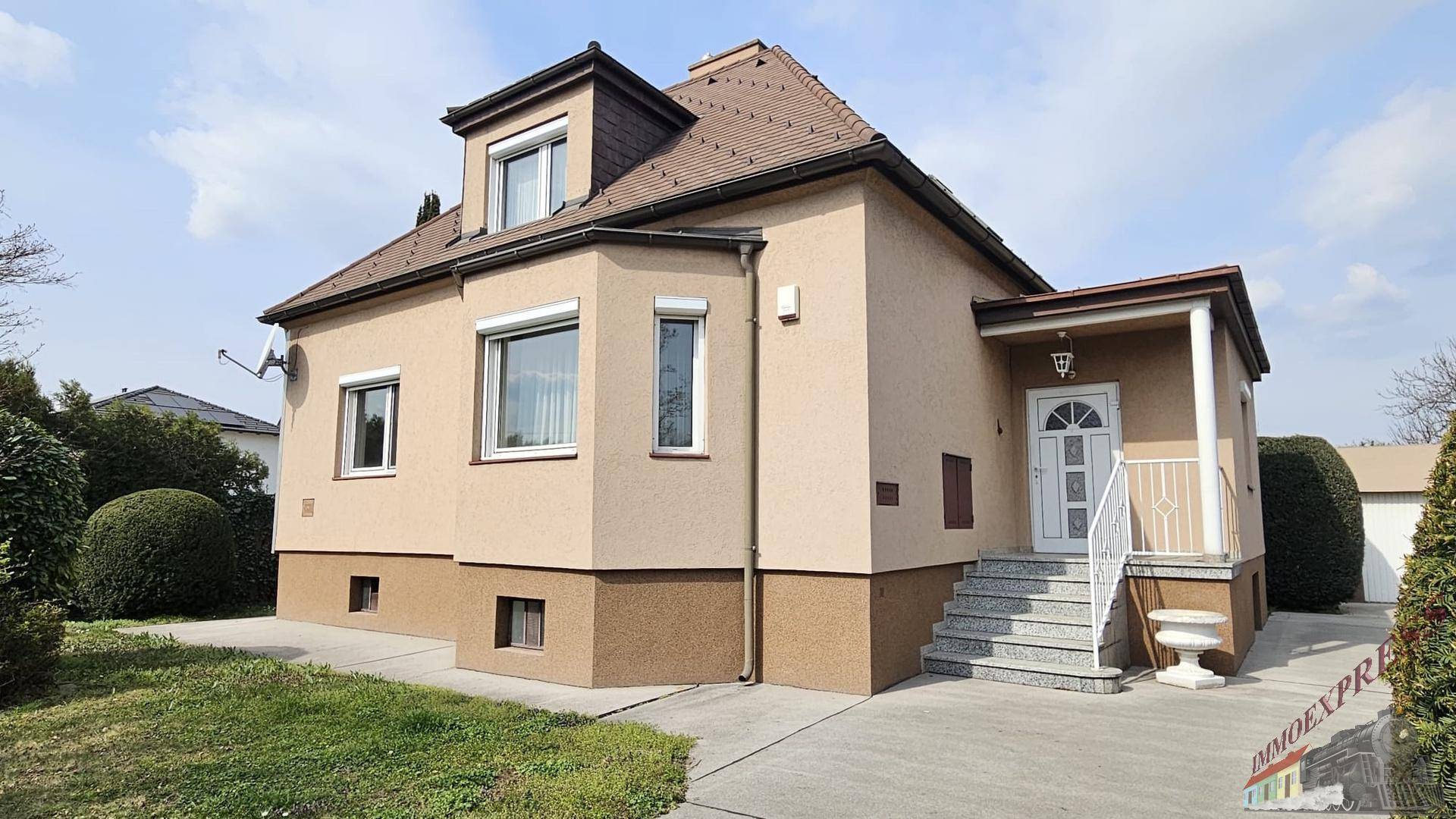 Ansicht des Einfamilienhauses von der Seite mit gepflegter Fassade und Vorgarten.