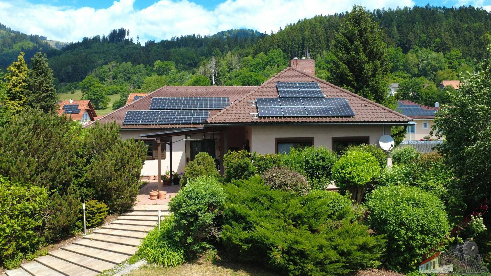 Vorderansicht des Hauses mit Solaranlagen auf dem Dach und einem einladenden Gartenweg.