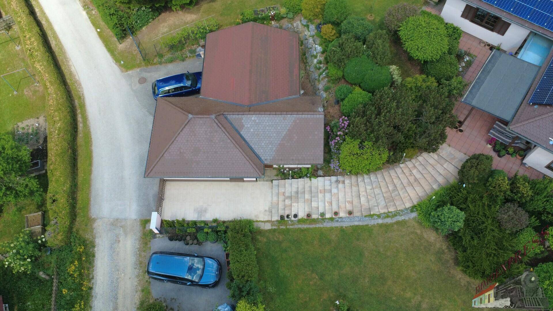 Vogelperspektive des Anwesens mit Zufahrt, Garage und weitläufigem Gartenbereich in ländlicher Umgebung.