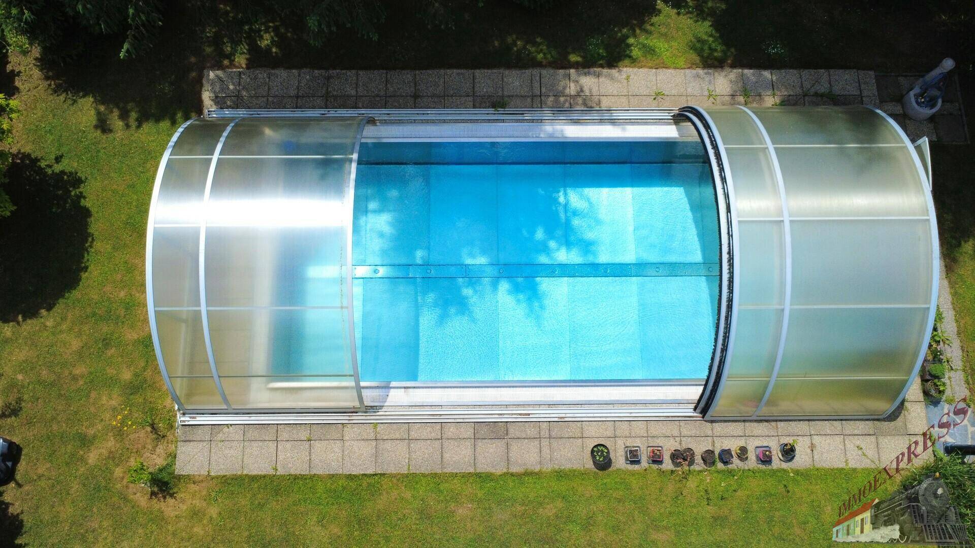 Nahaufnahme des überdachten Swimmingpools im Garten, bereit für die Nutzung an sonnigen Tagen.
