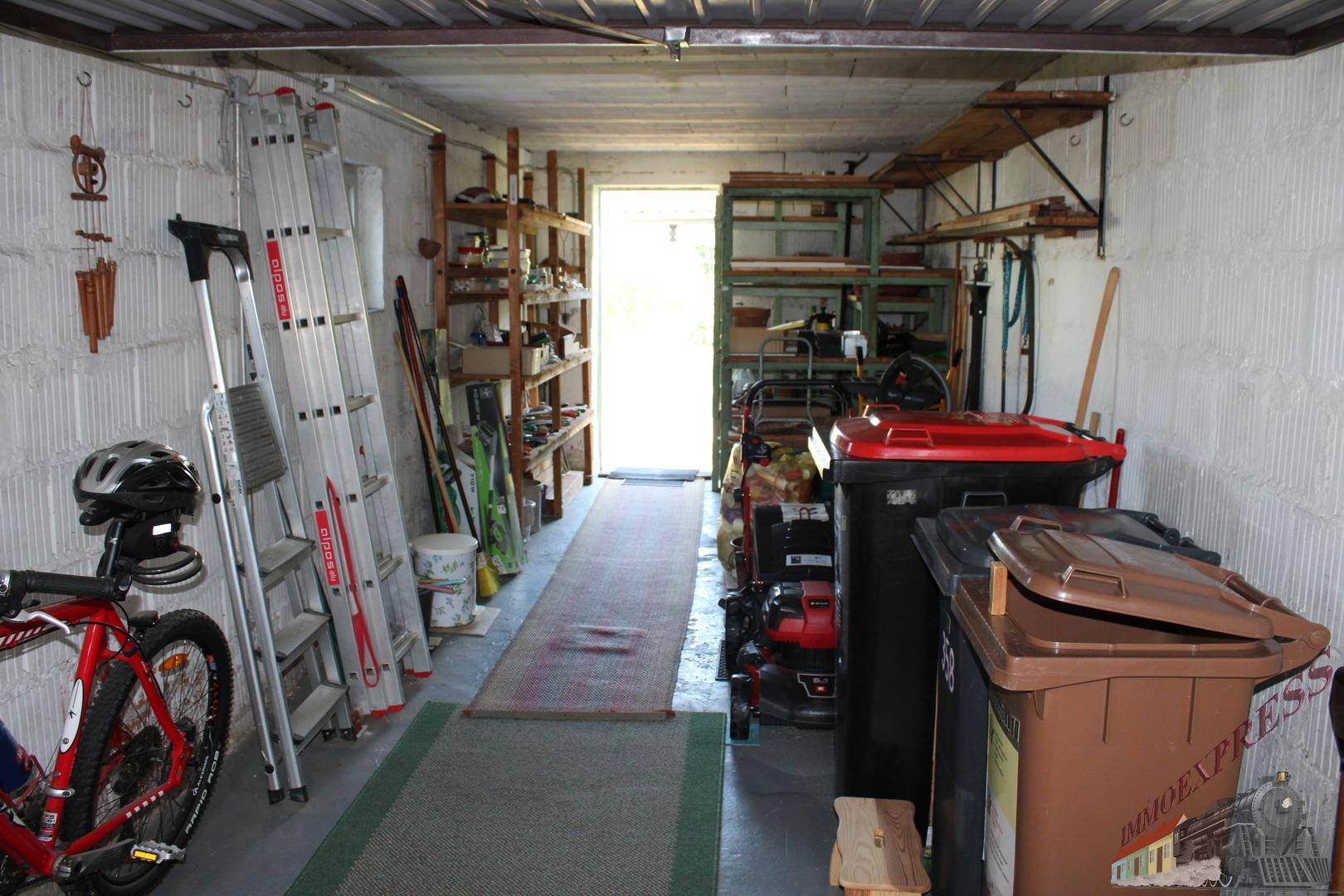 Garage mit umfangreichen Regalsystemen und Stauraum für Werkzeuge und Gartengeräte.