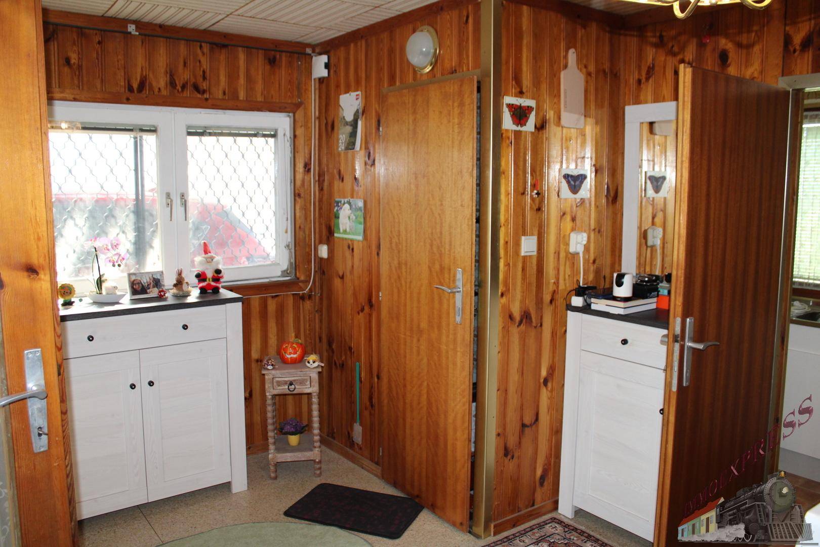 Flur mit Holzvertäfelung, Fenster und kleinen Schränken, funktional und einladend gestaltet.