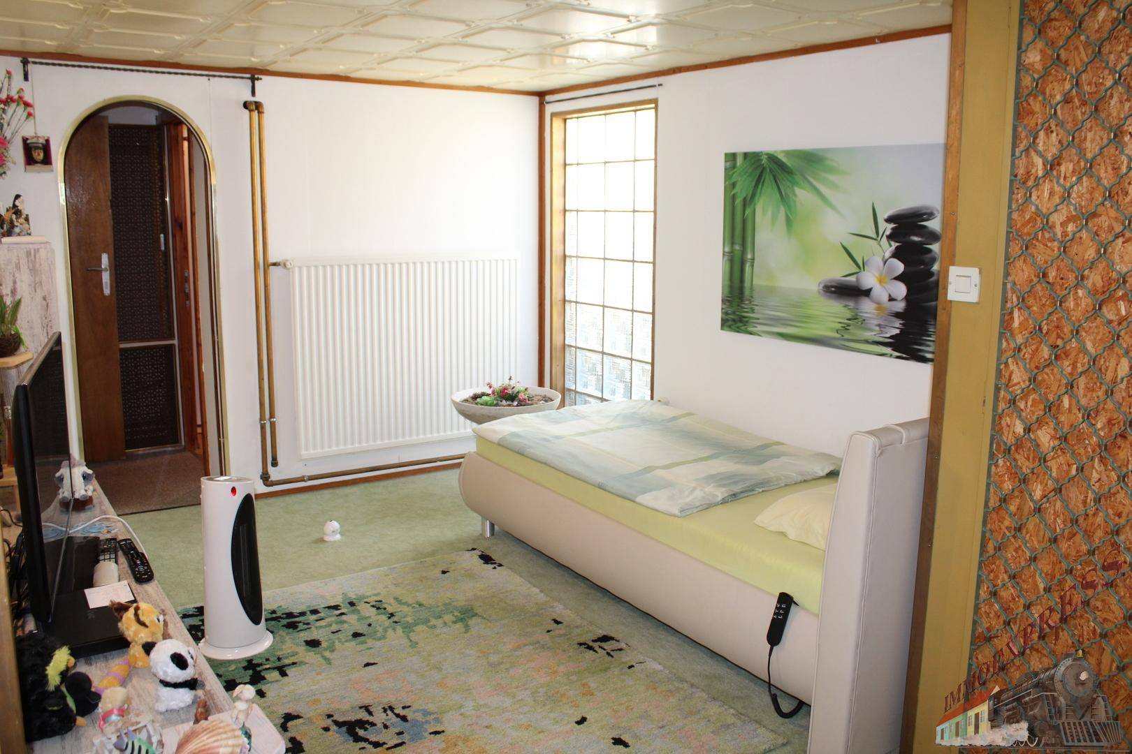 Helles Schlafzimmer mit Fenster, Heizkörper und einem bequemen Einzelbett, freundlich eingerichtet.