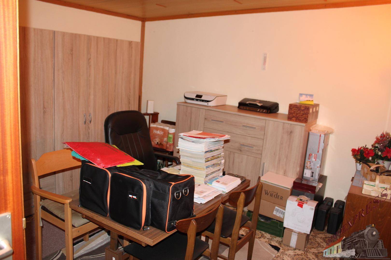 Arbeitszimmer mit Schreibtisch, Bürostuhl und Holzschränken, ideal für Home-Office-Tätigkeiten.