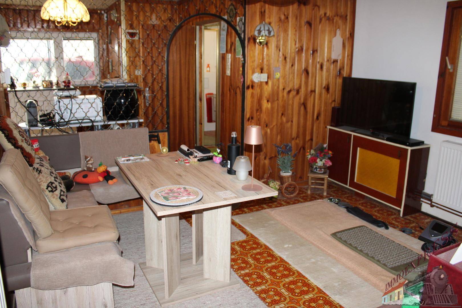 Gemütlicher Wohn- und Essbereich mit Holzvertäfelung, Esstisch und bequemer Sitzecke.