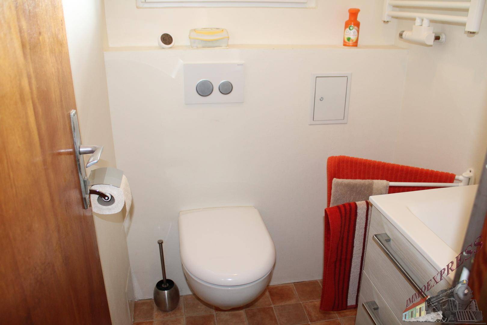 Kleines Gäste-WC mit wandhängender Toilette und praktischem Handtuchhalter, sauber und funktional.