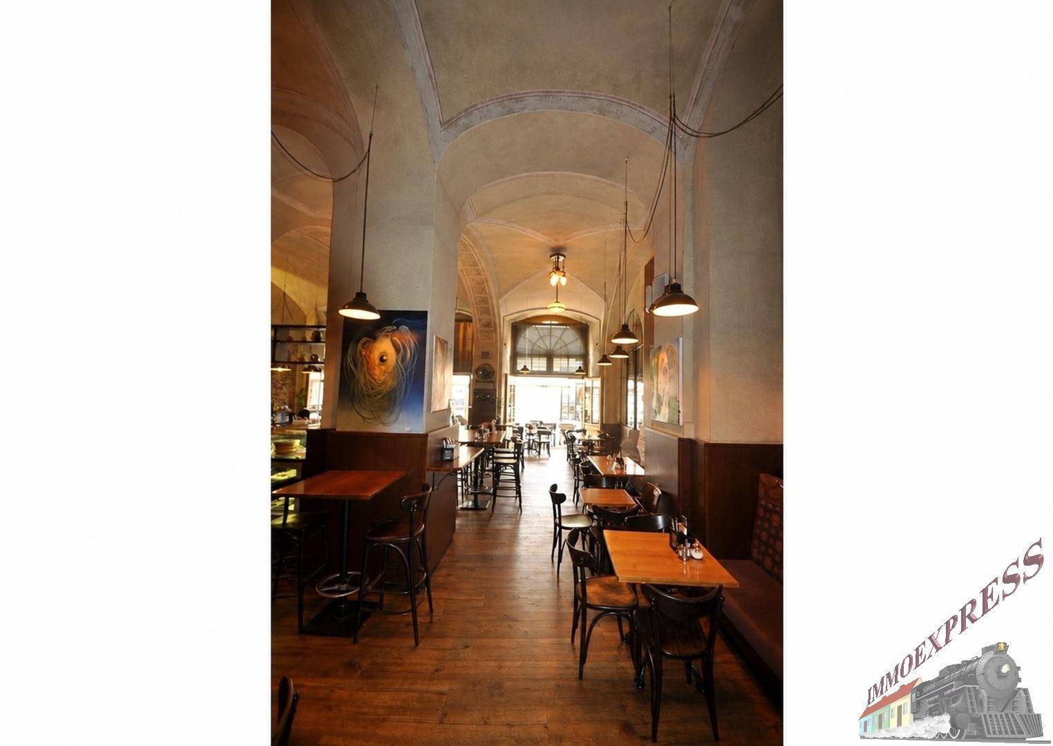 Langer Restaurantflur mit Holzböden, Gewölbedecken und Blick auf weitere Sitzbereiche und den Eingang.