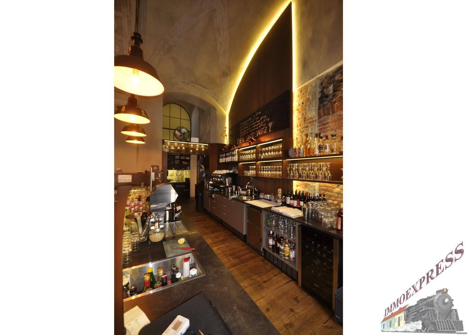 Detailansicht der Bar mit beleuchteten Regalen, Flaschen und Gläsern, sowie einer modernen Lichtinstallation.