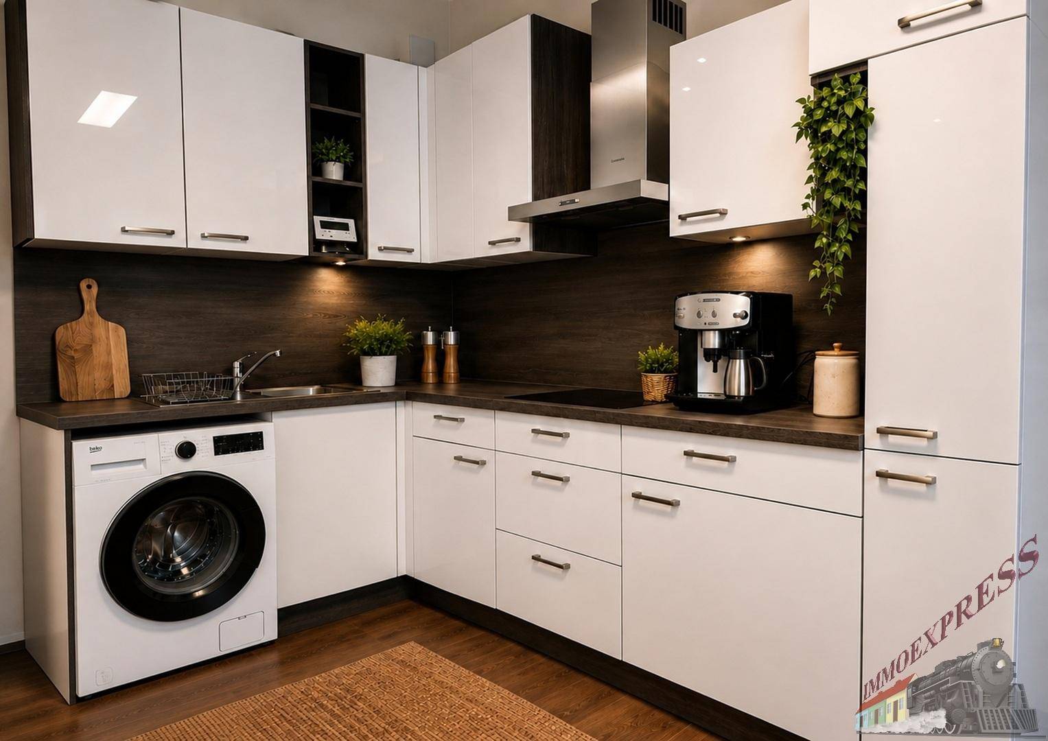 Moderne Küche mit weißen Hochglanzschränken, dunkler Arbeitsplatte und integrierter Waschmaschine.