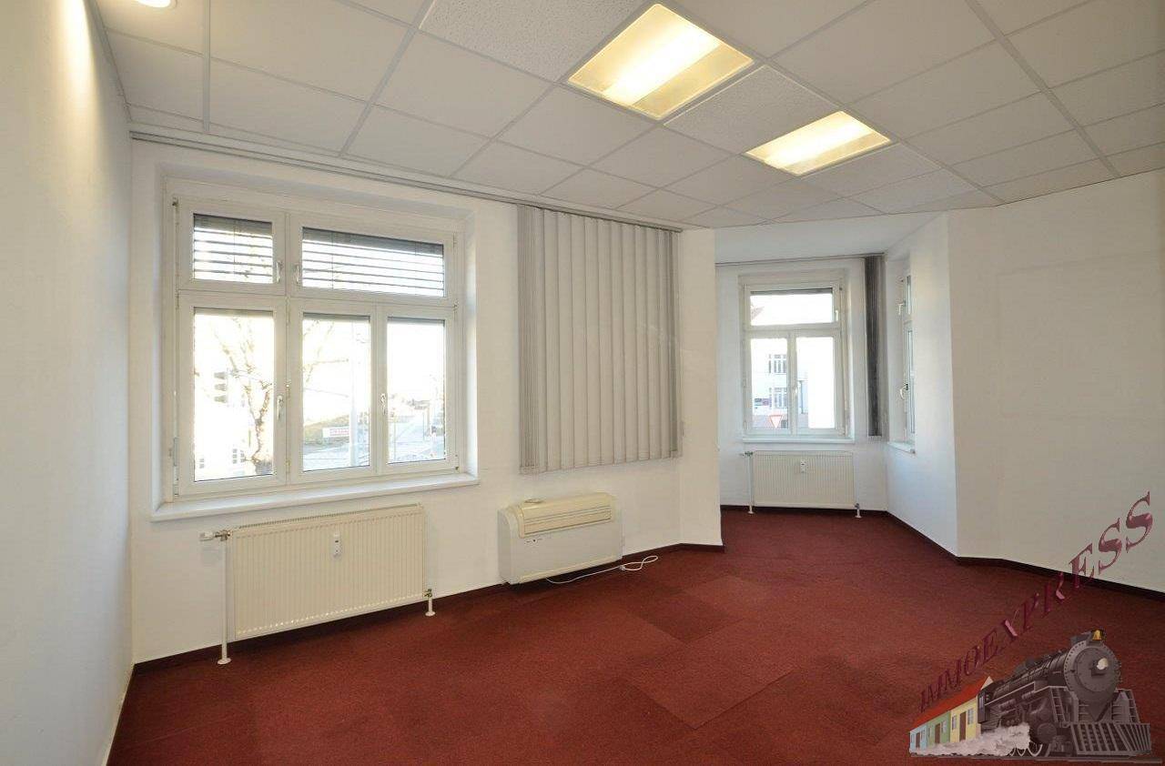 Geräumiges Büro mit Teppichboden, mehreren Fenstern und Jalousien für Sonnenschutz.