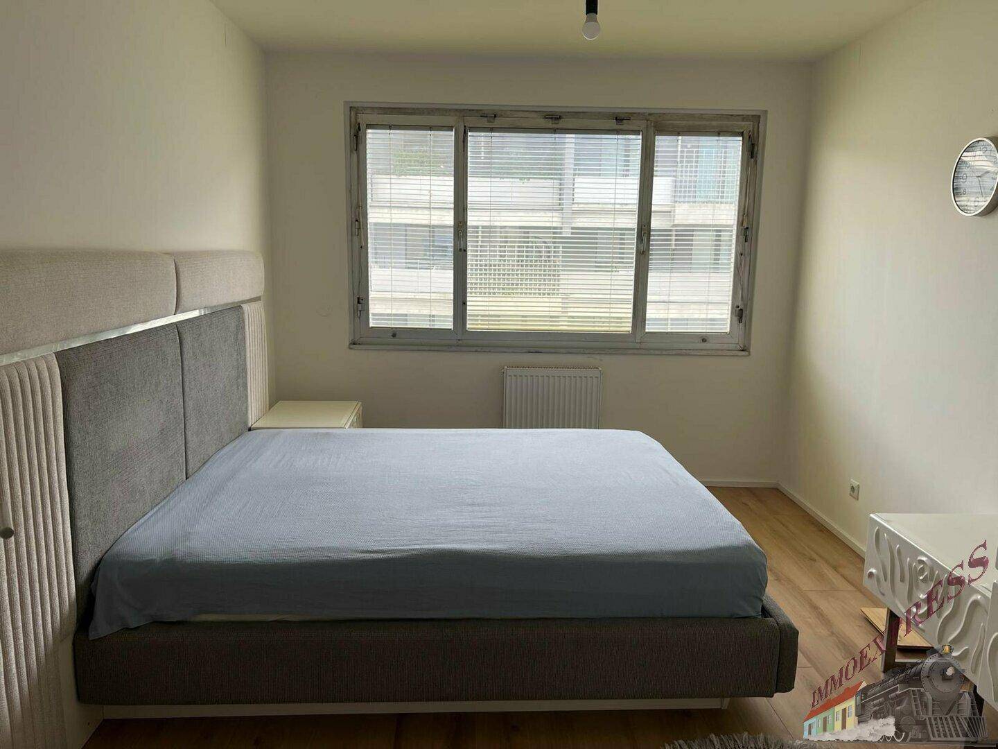 Schlafzimmer mit großem Doppelbett, Nachttischen und viel Tageslicht durch das Fenster.