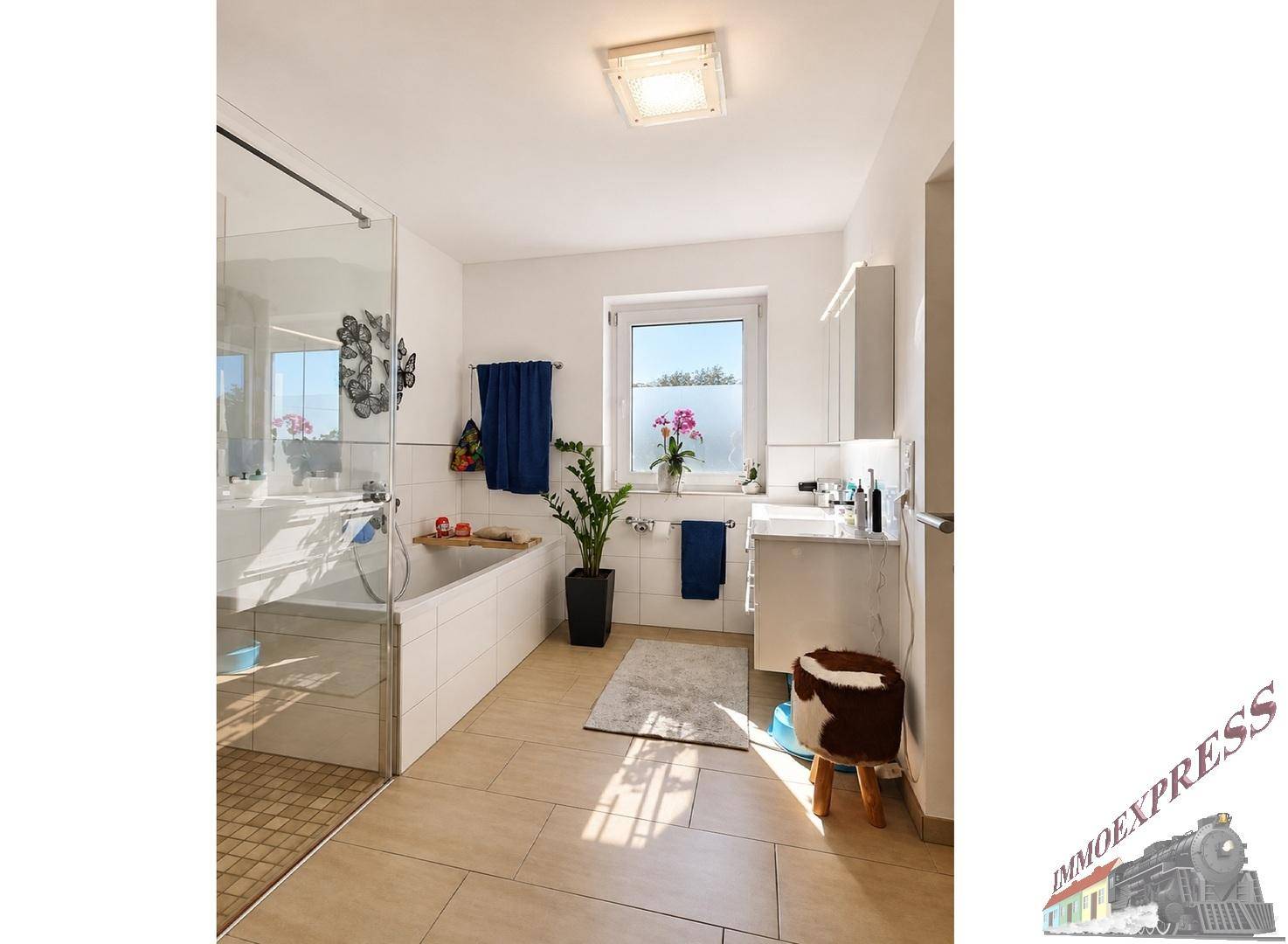 Geräumiges Badezimmer mit Badewanne, separater Dusche und Fenster für Tageslicht.