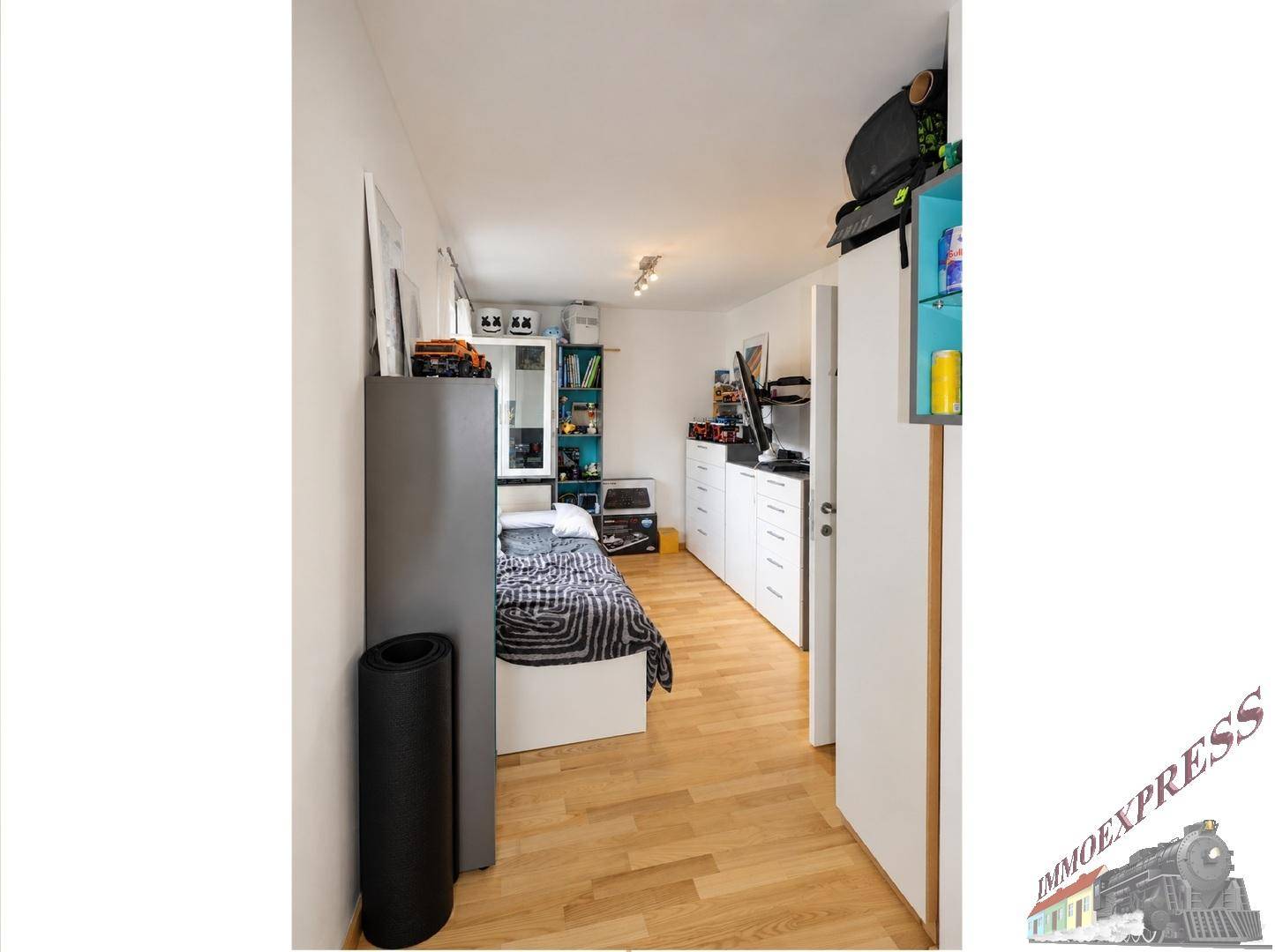 Helles Schlafzimmer mit Holzboden, Bett und Schränken, modern eingerichtet.