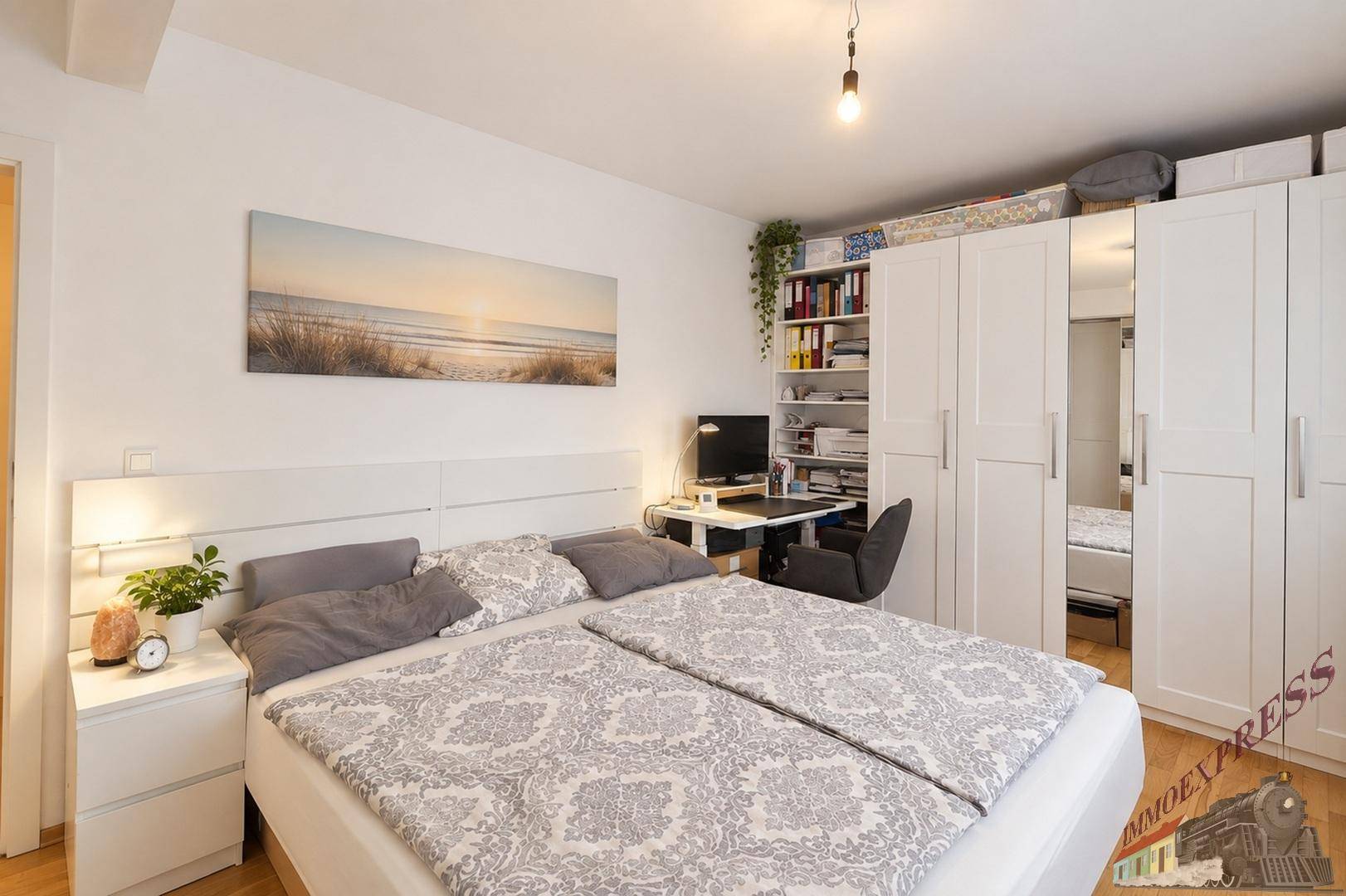 Geräumiges Schlafzimmer mit Doppelbett, Schreibtisch und großen Kleiderschränken.
