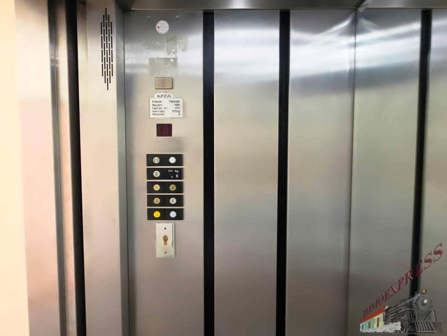 Detailansicht der Bedienfelder eines Aufzugs mit Edelstahltüren und Beschriftungen.