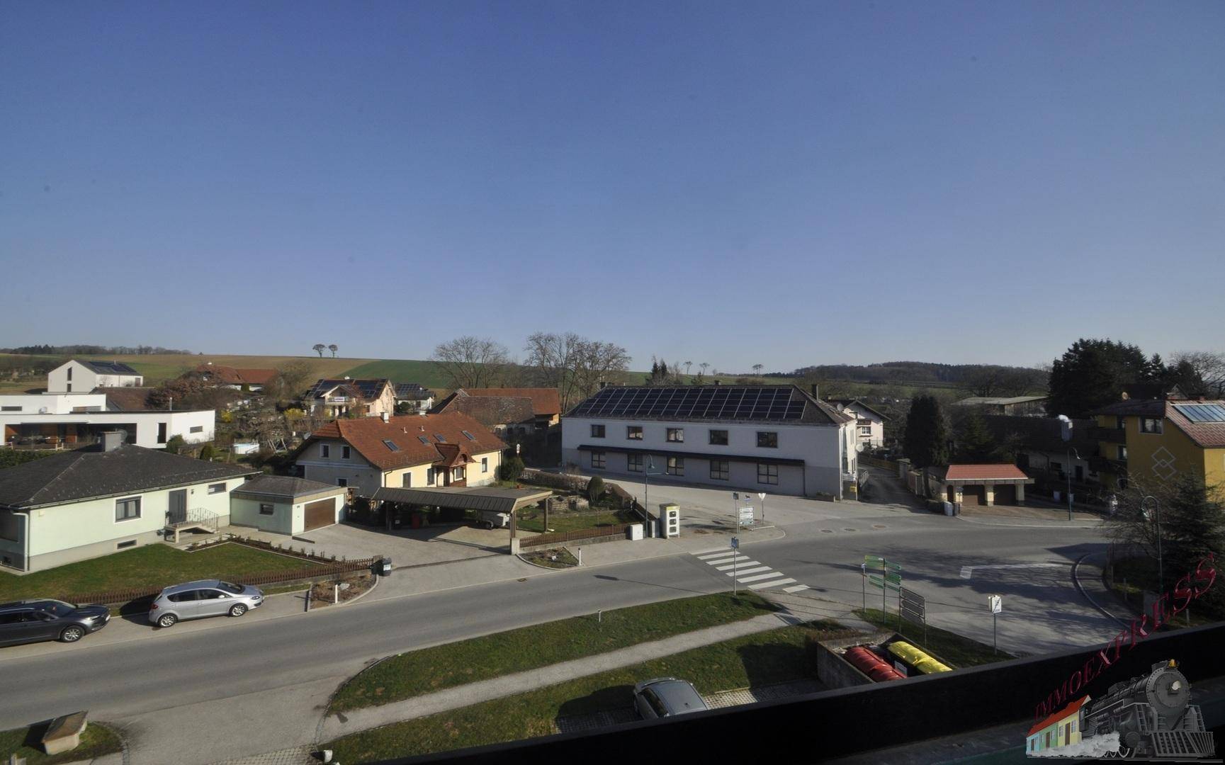 Panoramablick von der Wohnung auf die umliegende Wohngegend und weite Felder.