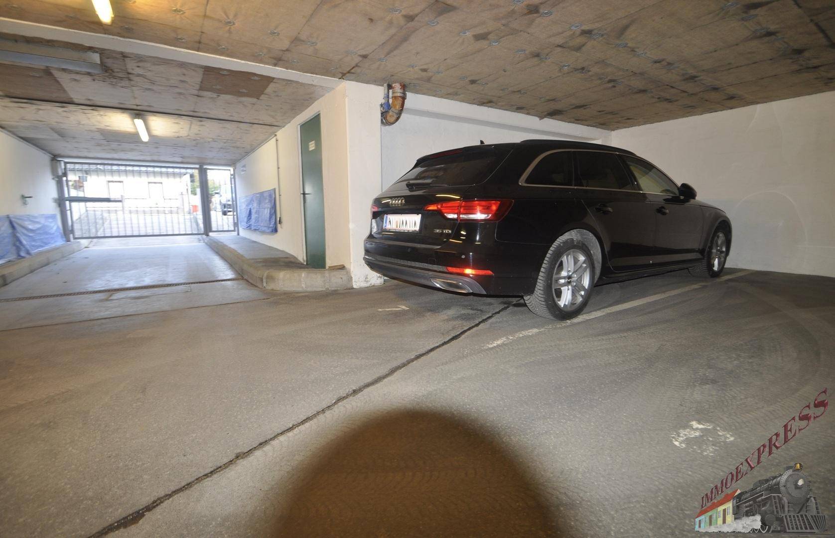 Tiefgarage mit einem geparkten Auto und Zugang zur Straße.