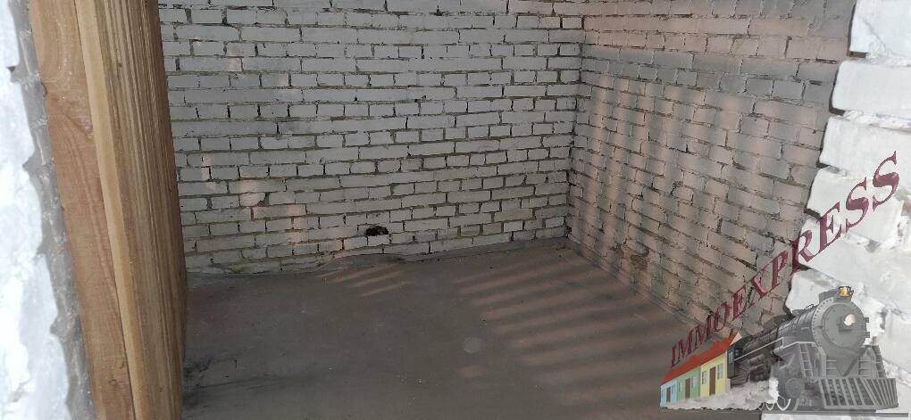 Unfertiger Kellerraum mit unverputzten Ziegelwänden und Betonboden, ideal als Lagerfläche.
