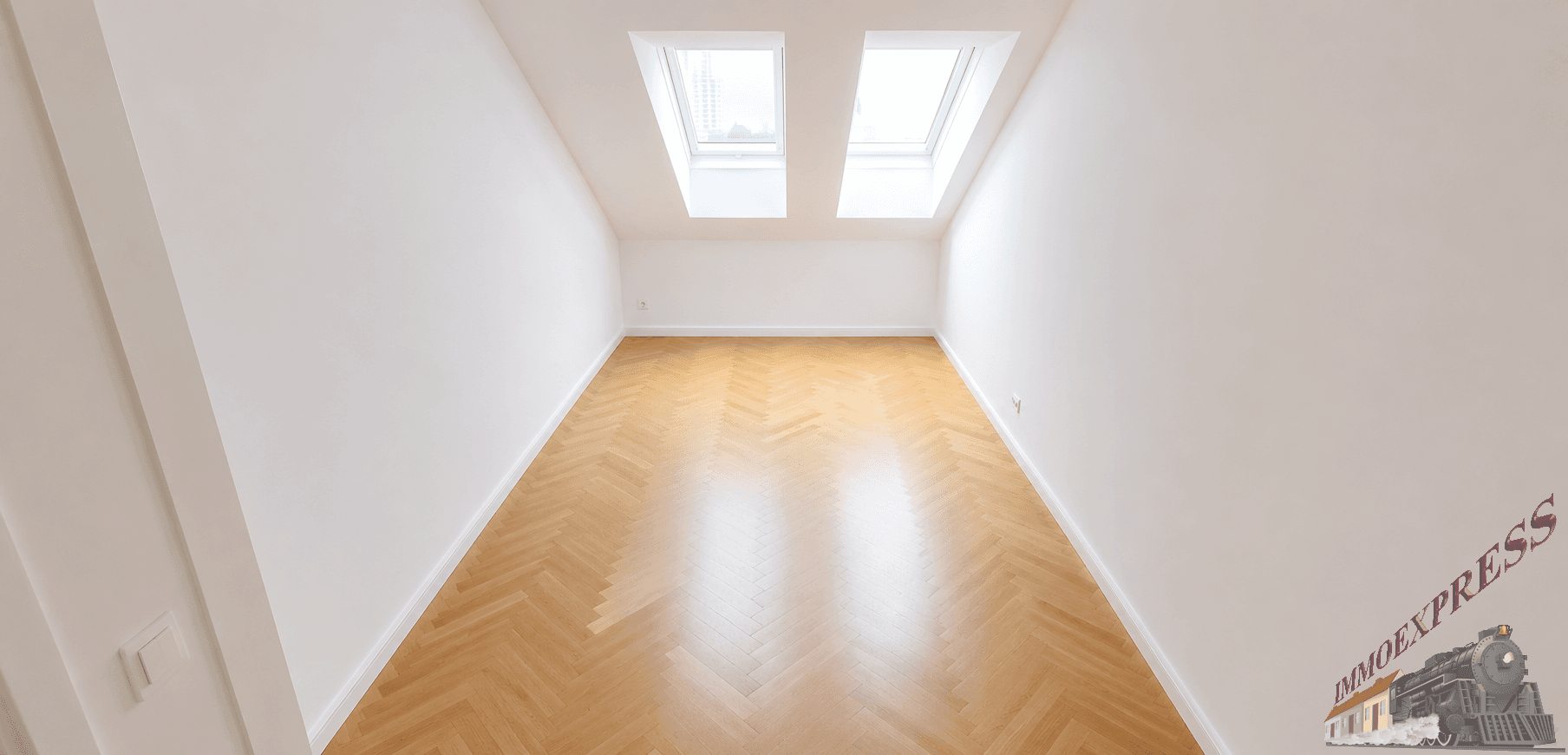 Geräumiges Zimmer mit Parkettboden und zwei Dachfenstern, bietet viel natürliches Licht.