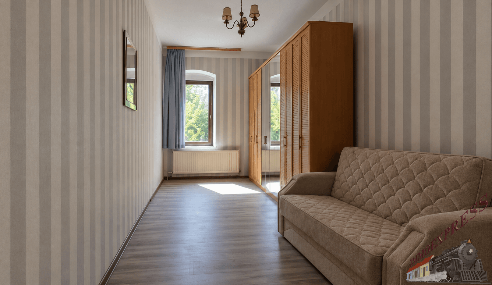 Schlafzimmer mit gestreiften Tapeten, einem Schlafsofa und einem großen Spiegelschrank.
