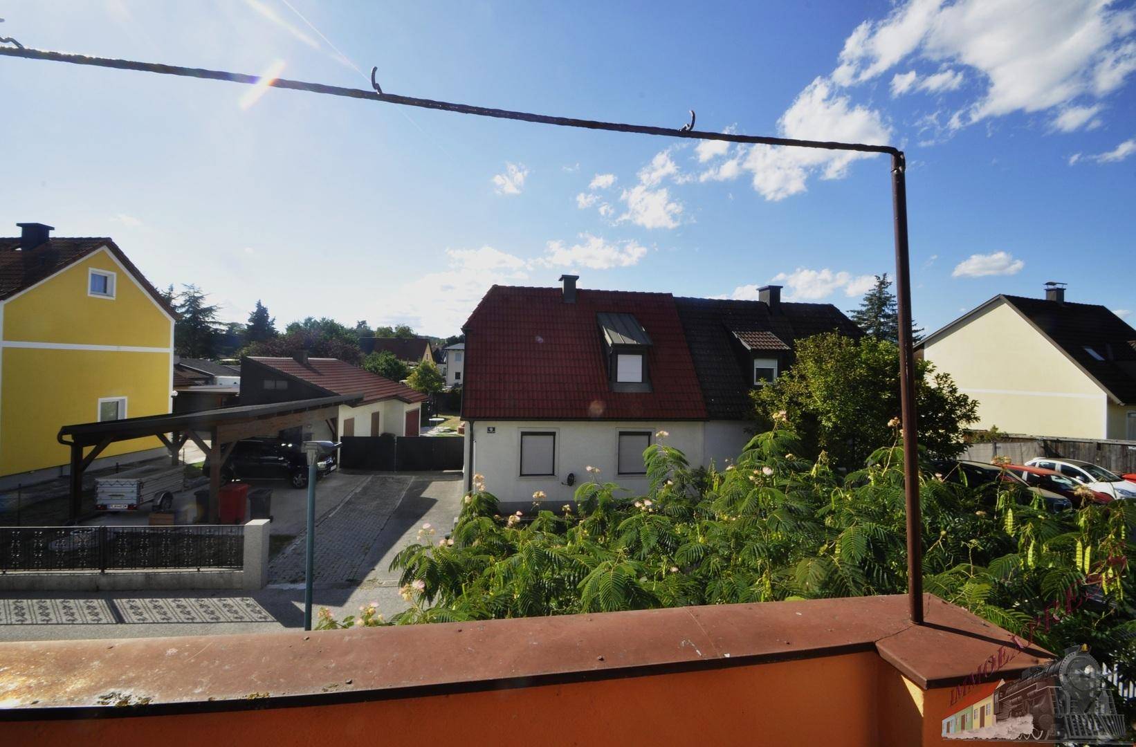 Weitläufiger Blick über die Nachbarschaft mit verschiedenen Häusern und viel Grün.