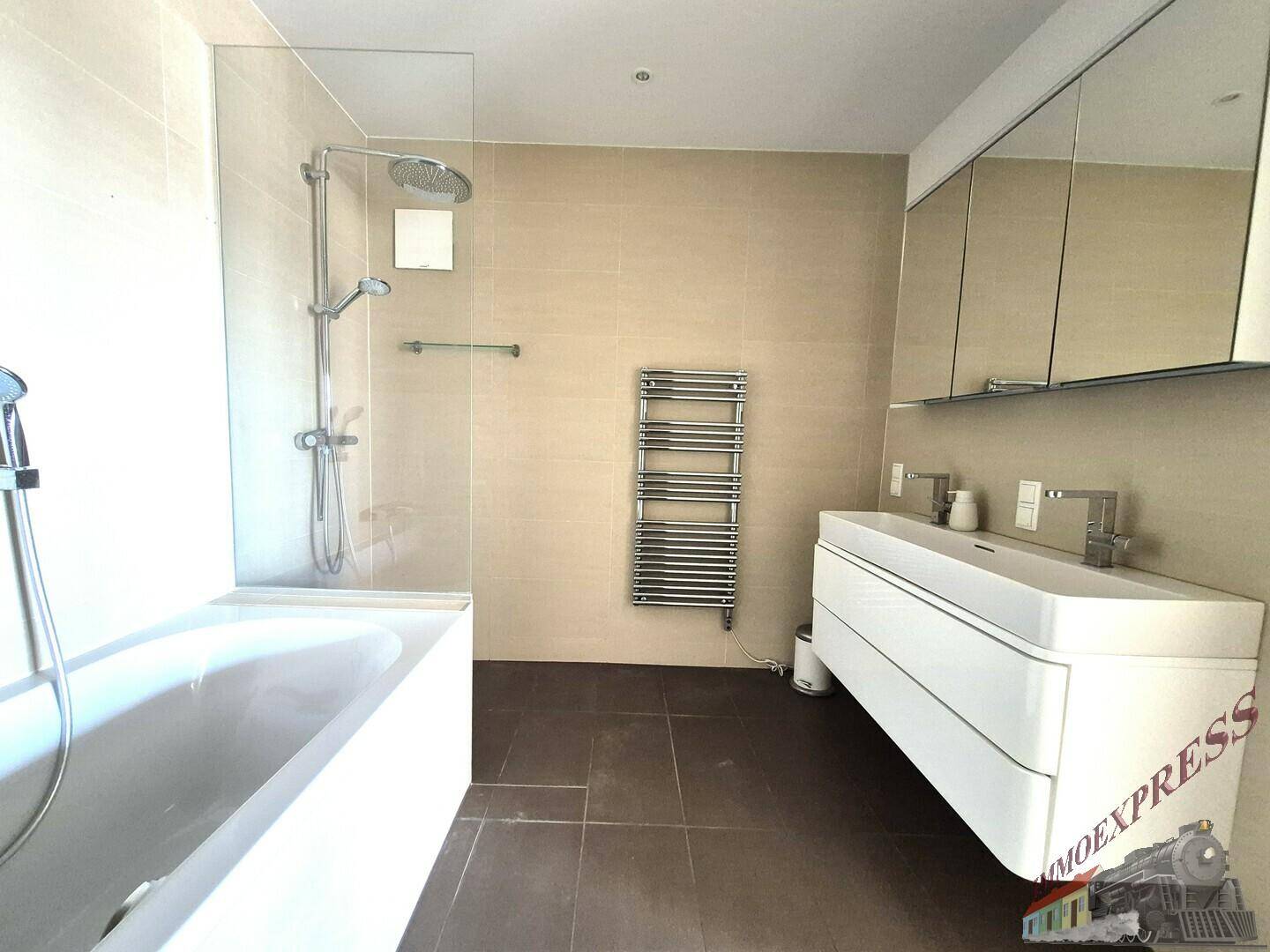 Modernes Badezimmer mit Badewanne, Dusche, Doppelwaschbecken und beheiztem Handtuchhalter.
