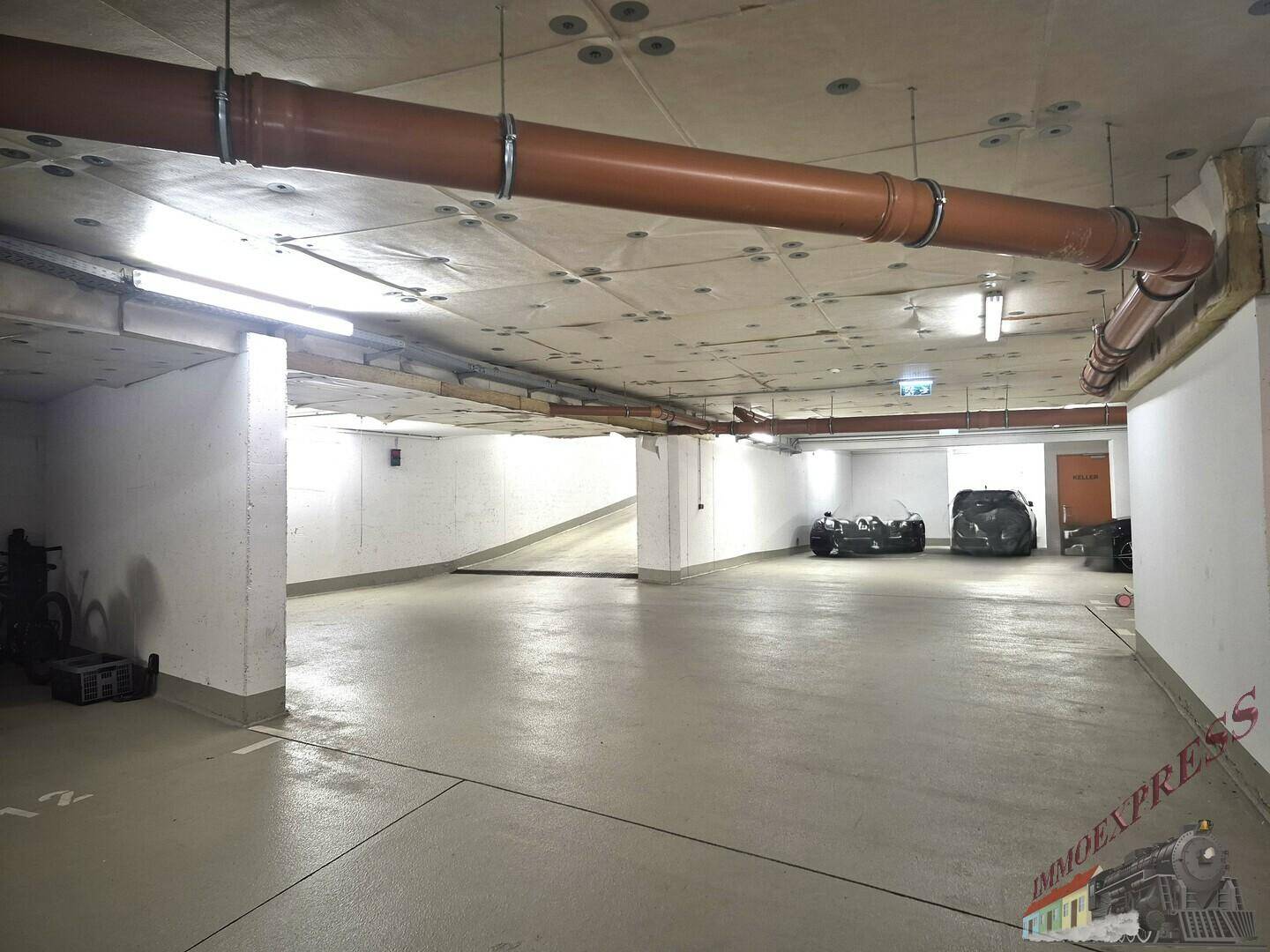 Geräumige Tiefgarage mit Betonboden und ausreichend Stellplätzen für mehrere Fahrzeuge.