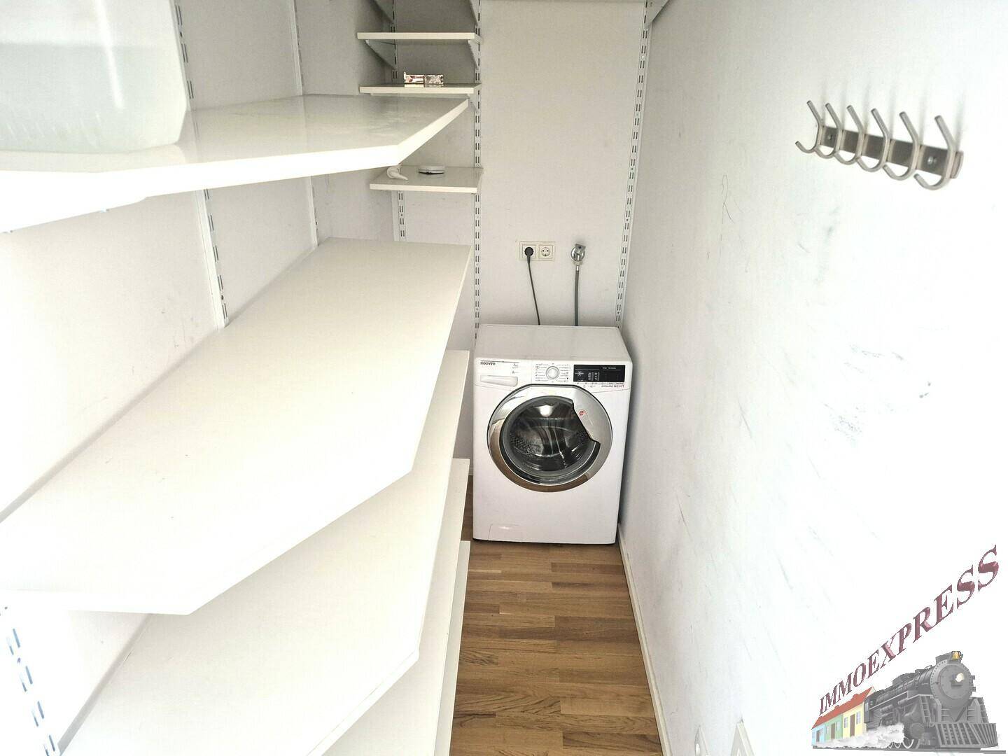 Praktischer Hauswirtschaftsraum mit Waschmaschine und Regalsystem für zusätzlichen Stauraum.