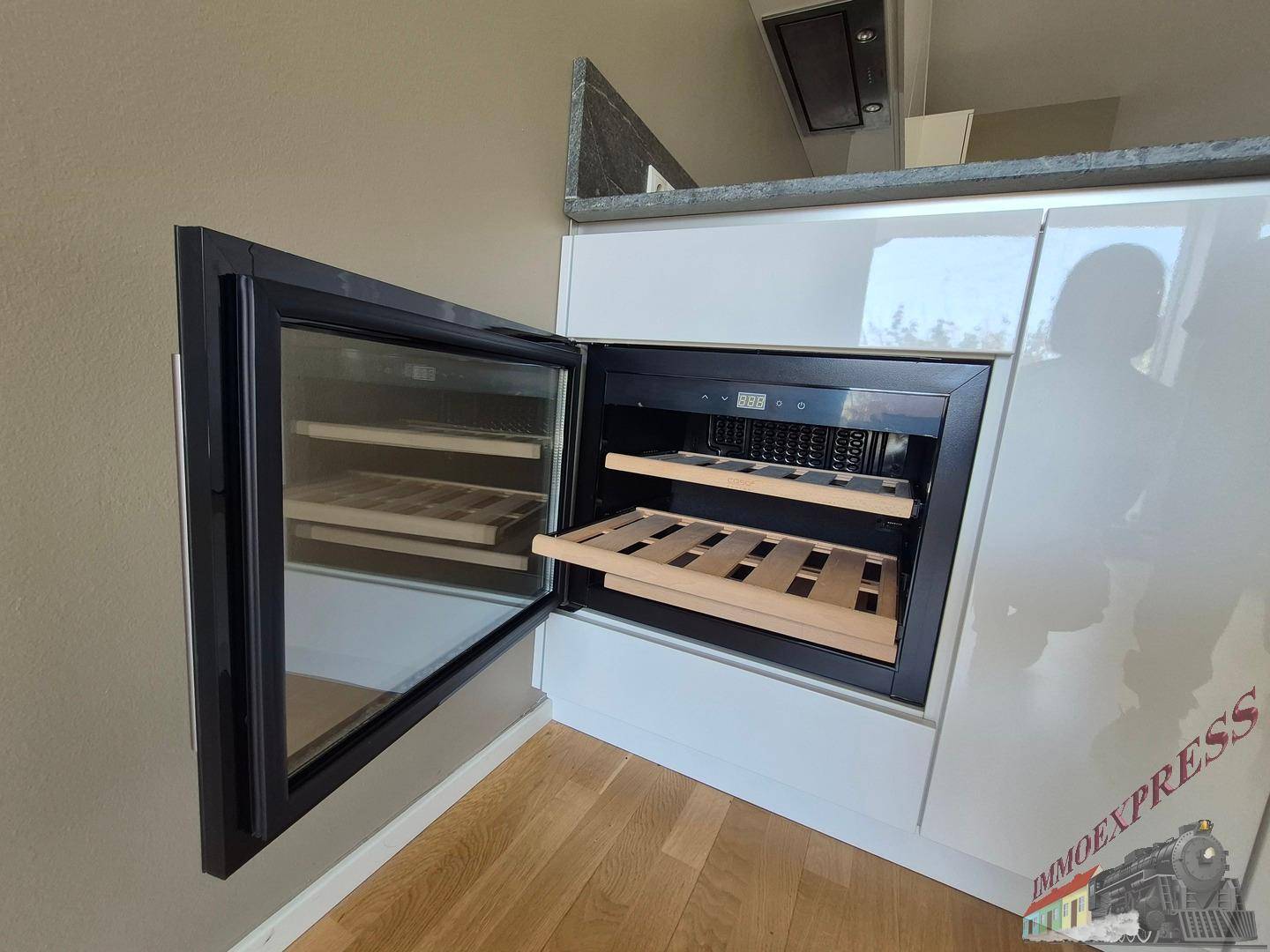 Integrierter Weinkühlschrank in der modernen Küche mit Holzparkettboden, ideal für Weinliebhaber.