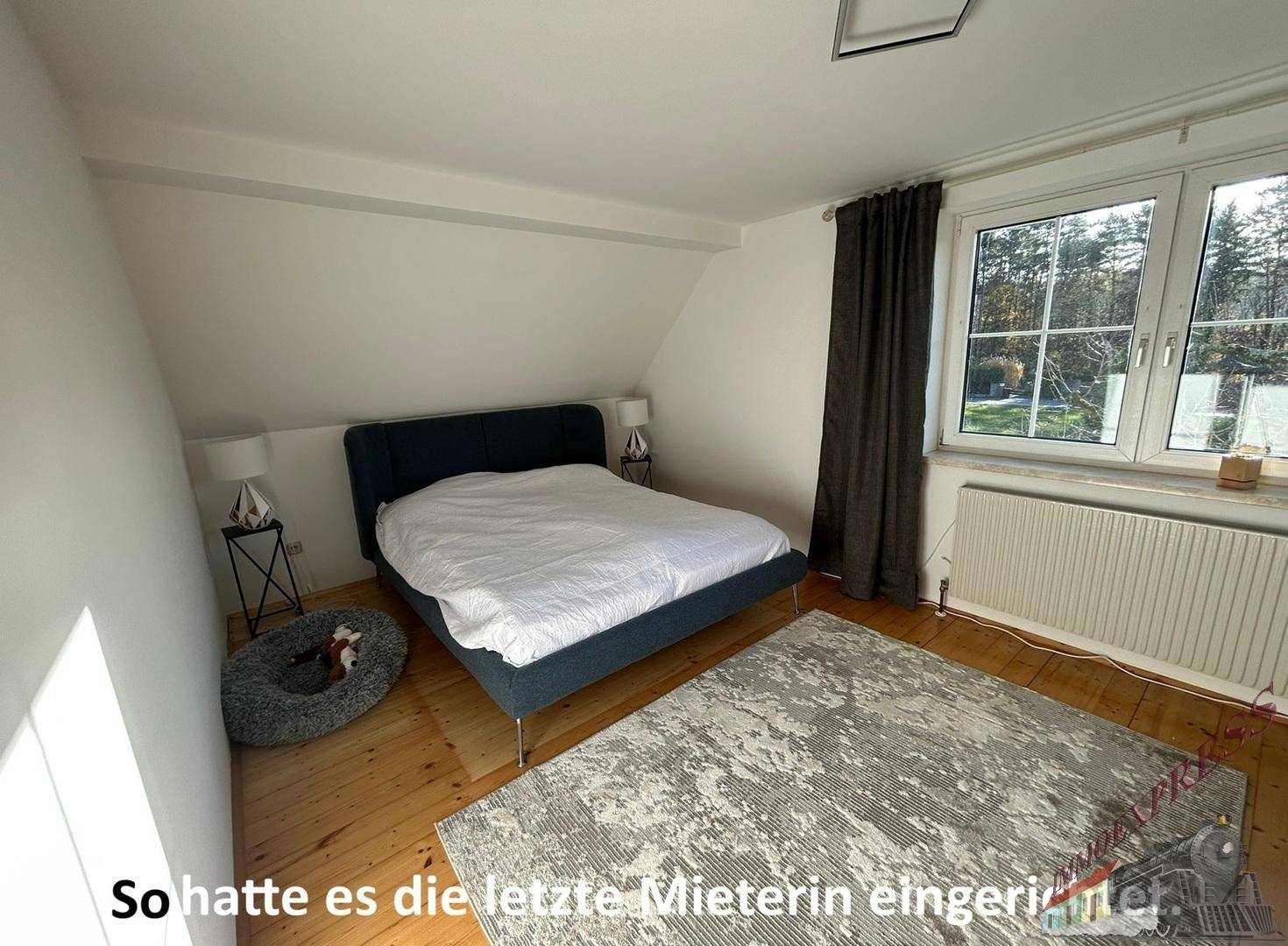 Gemütliches Schlafzimmer, eingerichtet von der Vormieterin, mit Bett, Teppich und Vorhängen.