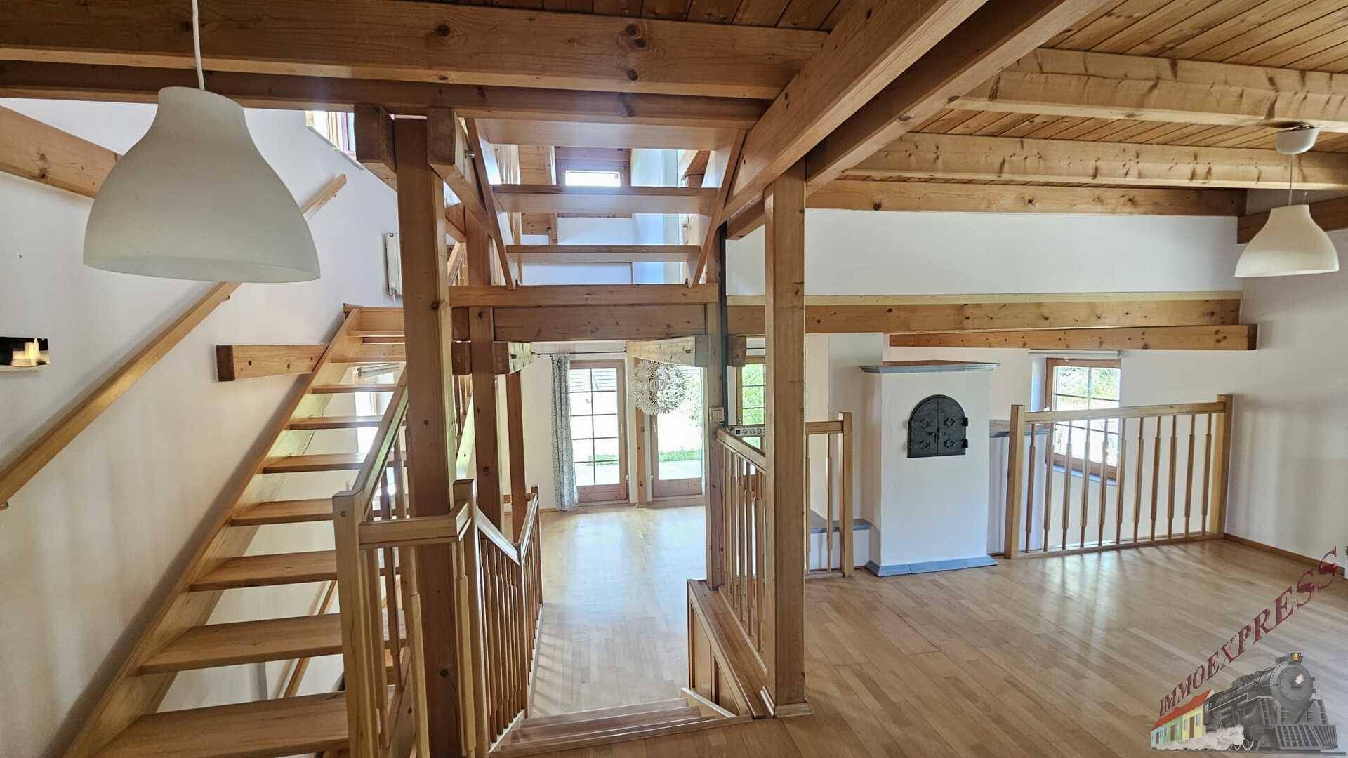 Offener Treppenbereich mit Holzgeländer und Blick auf den unteren Wohnbereich.