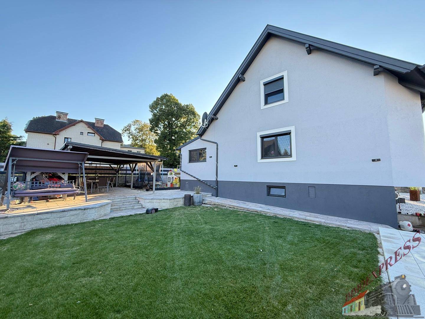 Großer Garten mit Rasenfläche und überdachter Terrasse für gemütliche Stunden im Freien.