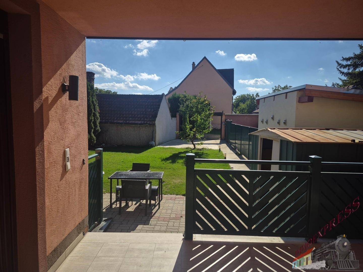 Überdachte Terrasse mit Sitzgelegenheiten und Blick auf den grünen Garten.