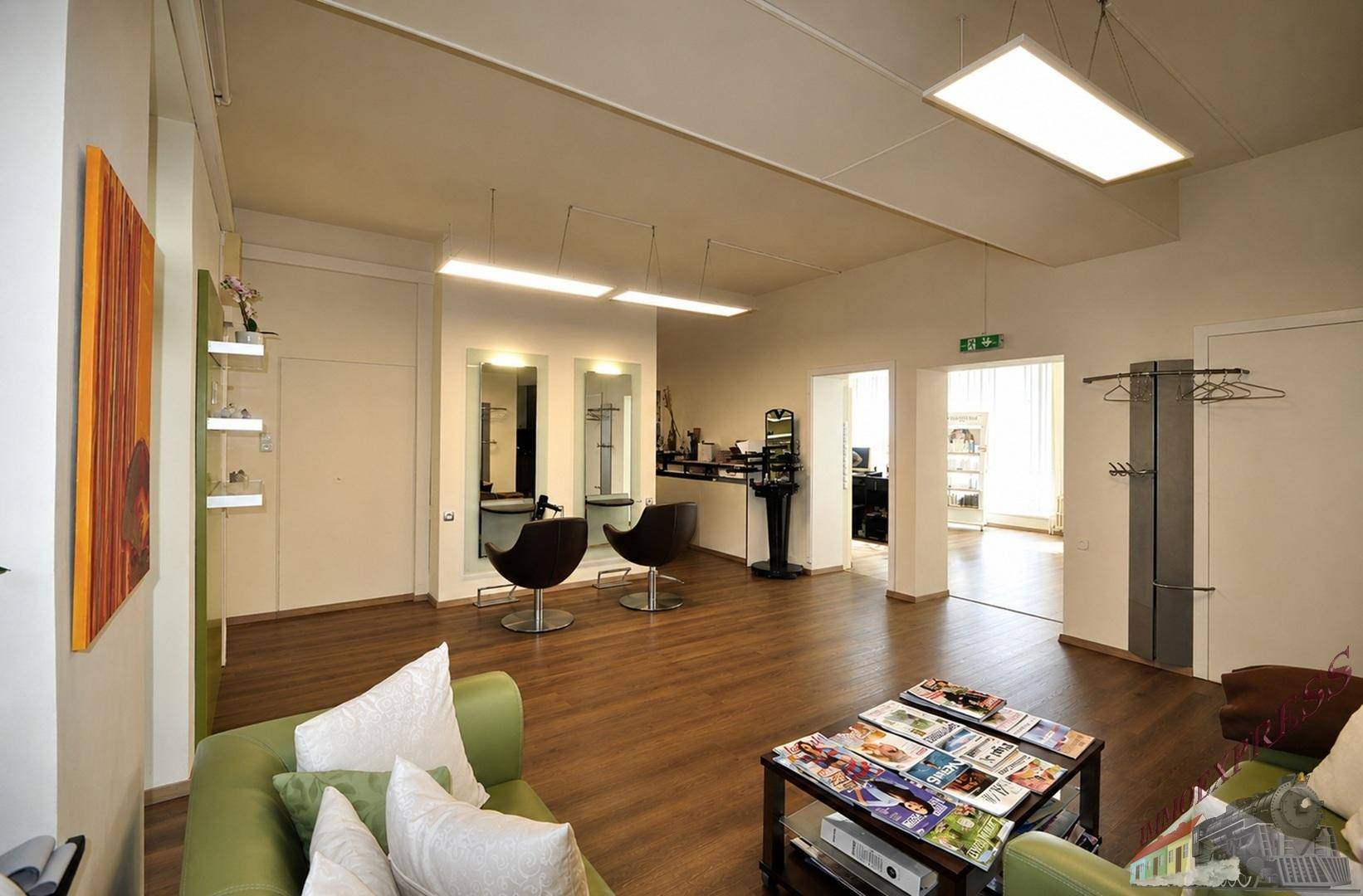 Gemütlicher Wartebereich mit bequemen Sofas und Blick auf den Friseurbereich, einladend und entspannend.