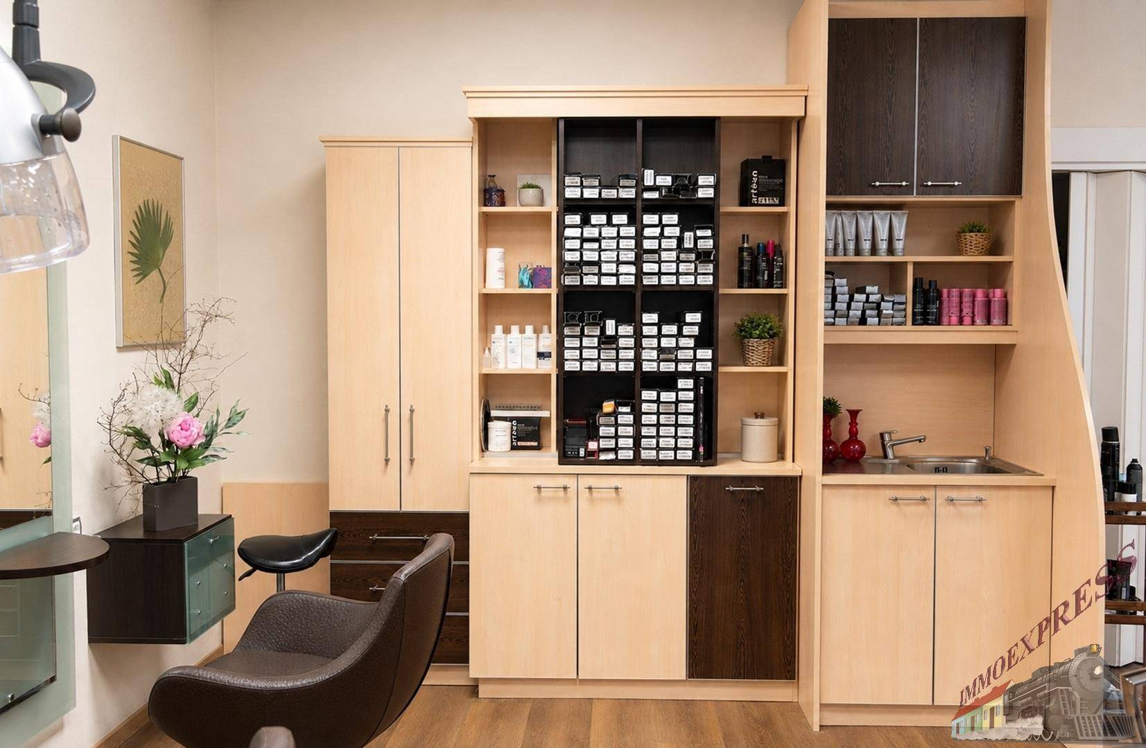 Arbeitsbereich in einem Friseursalon mit Produktregalen, Schränken und Waschbecken, gut organisiert.