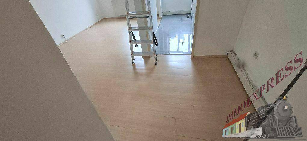Leeres Zimmer mit Laminatboden und einem Durchgang zu einem weiteren Bereich, bereit zur Einrichtung.