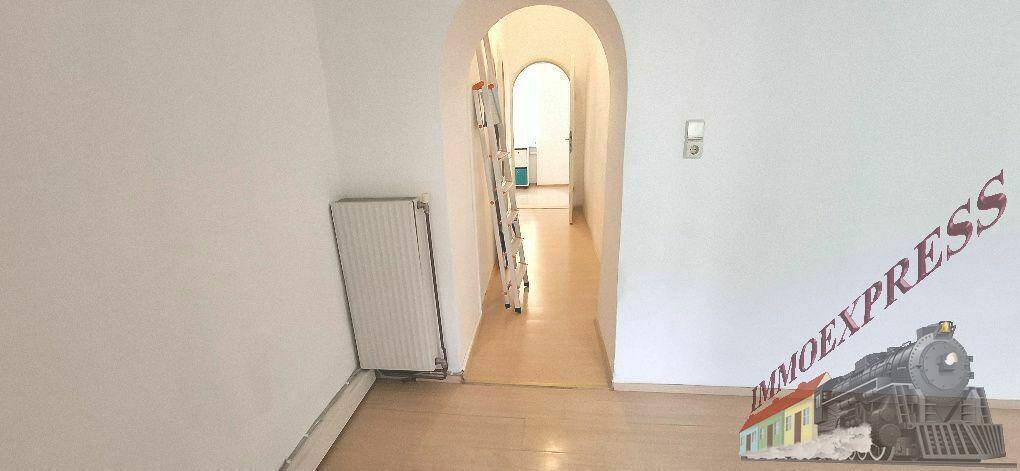 Heller Flur mit Laminatboden und einem eleganten Rundbogen, der zu weiteren Räumen führt.