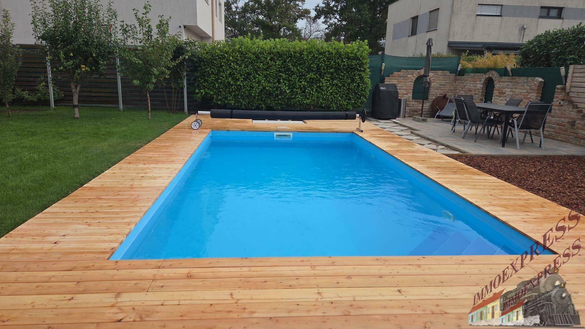 Gepflegter Außenbereich mit großem Swimmingpool, Holzdeck und gemütlicher Sitzecke im Garten.
