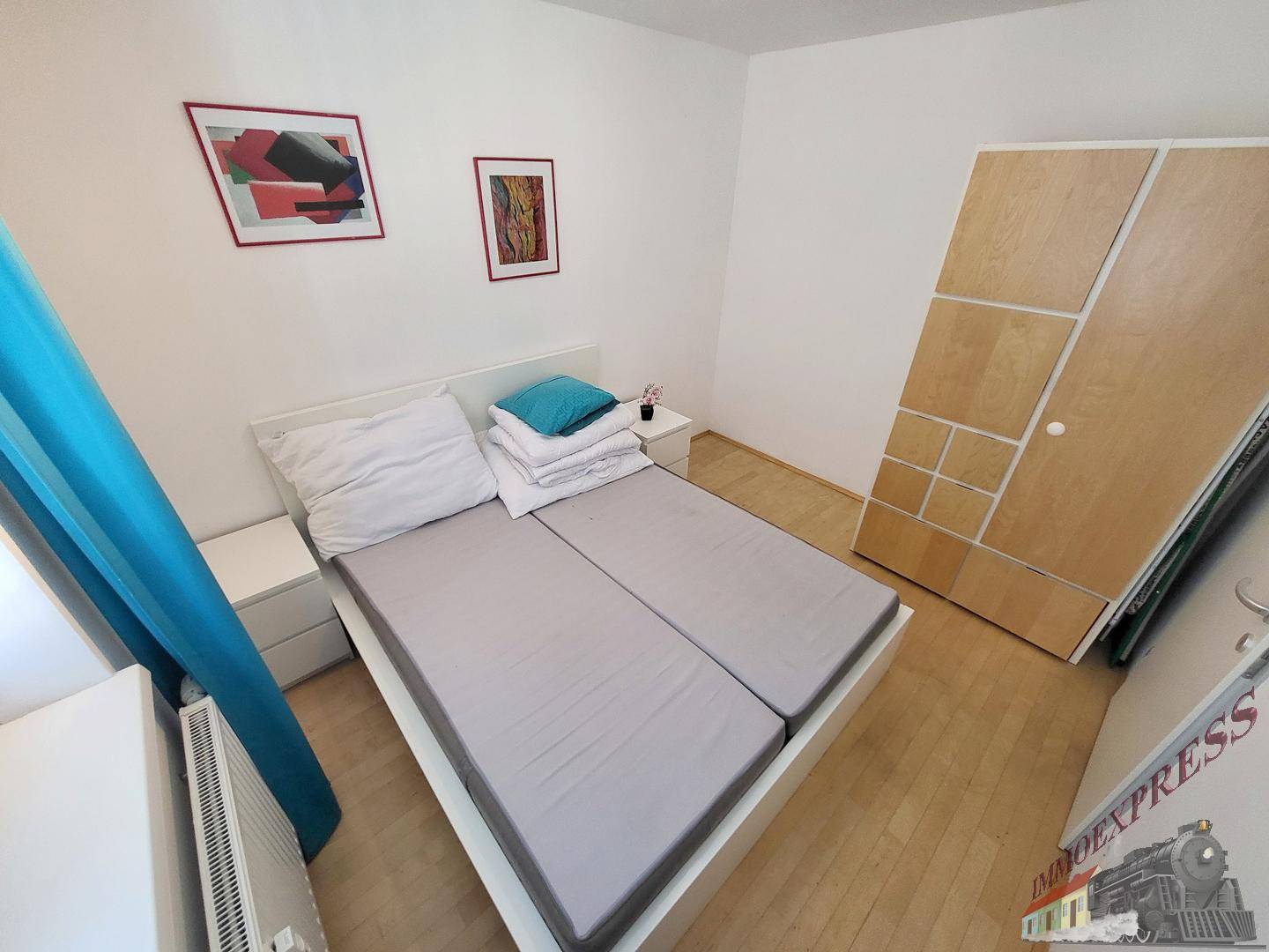 Schlafzimmer mit Doppelbett, Nachttischen und großem Kleiderschrank.