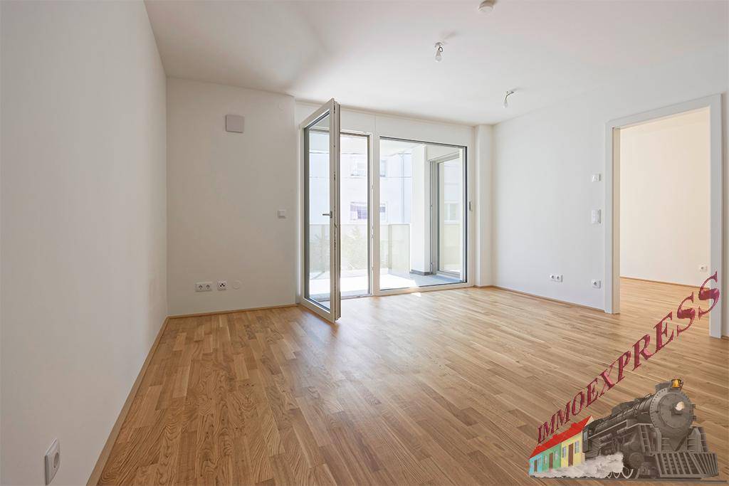 Geräumiges Wohnzimmer mit Parkettboden und großen Fenstern, die viel Tageslicht hereinlassen.