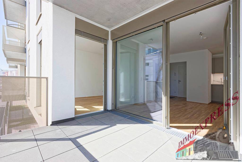 Geräumiger Balkon mit Fliesenboden und Schiebetüren, die zu den Innenräumen führen.