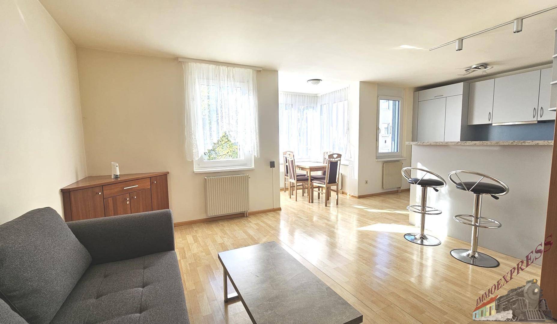 Gemütlicher Wohnbereich mit Sofa, Couchtisch und Blick auf den Essbereich und die Küche.