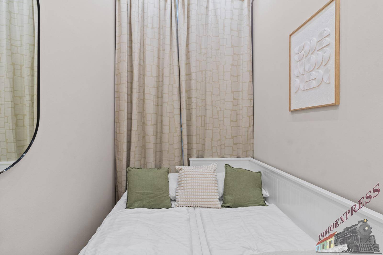Gemütliches Schlafzimmer mit Einzelbett, hellen Vorhängen und modernem Wanddekor in neutralen Tönen.