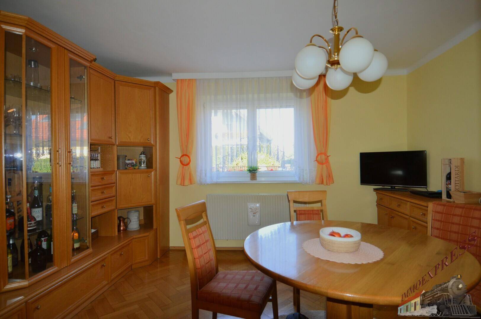 Gemütlicher Essbereich mit Holztisch, Stühlen und großem Wandschrank in traditionellem Stil.